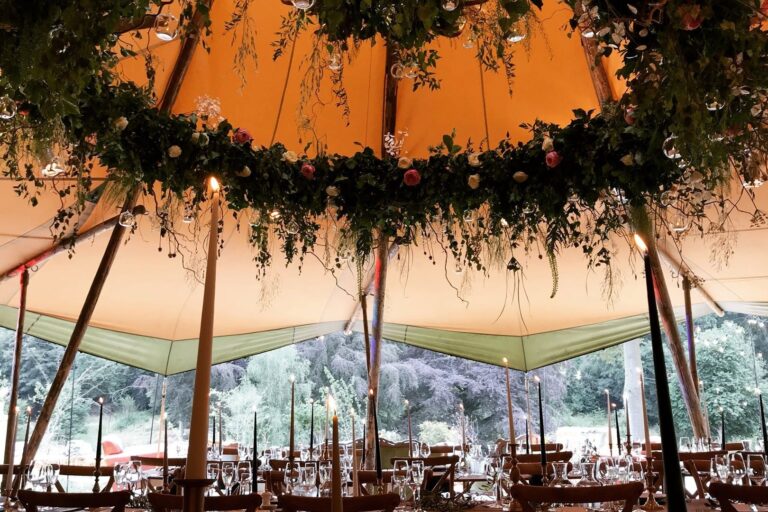 Inside a marquee, beneath a foliage-hung ceiling, Cornwell Manor