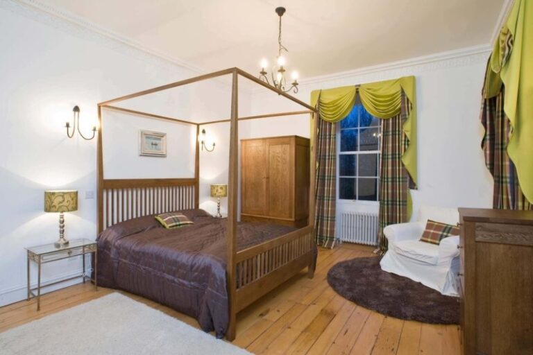 A four-poster bedroom in dark wood, Cortes House