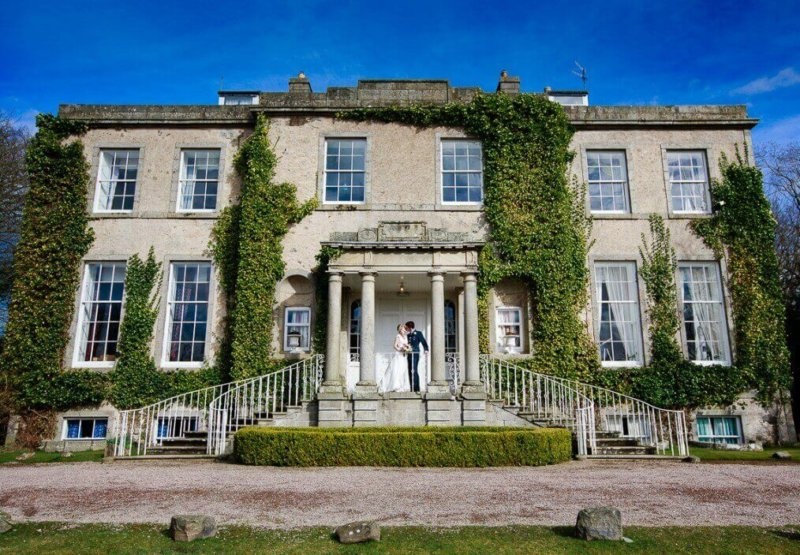 A couple on the steps of the ivy-clad house, Cortes House
