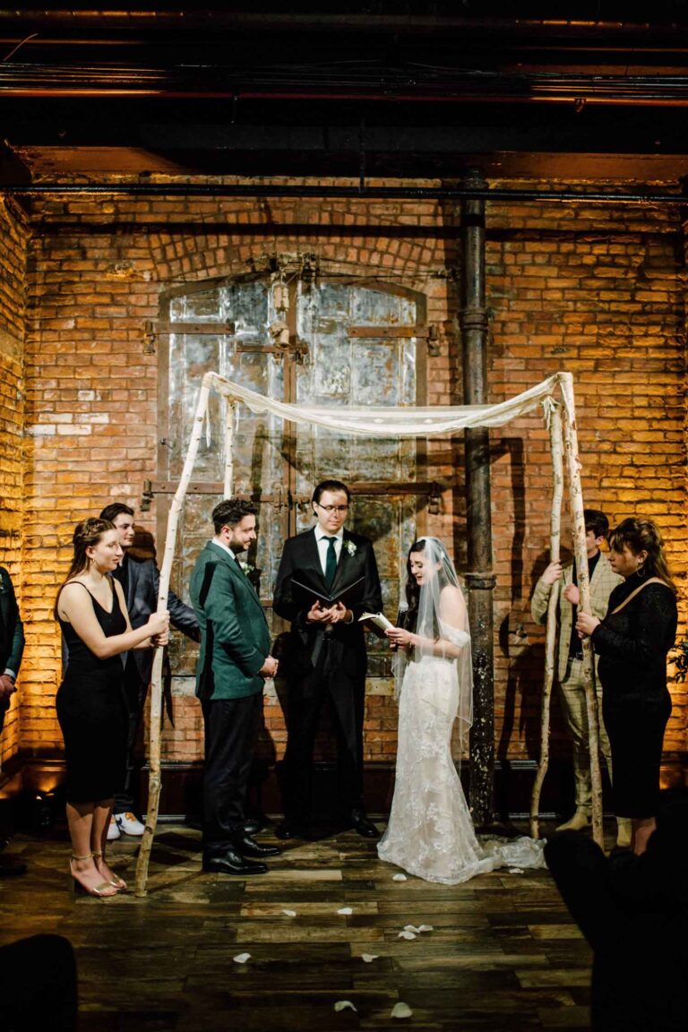 Ceremony under a chuppah in a brick-walled room, from a wedding in DUMBO, Brooklyn, Cottonwood Studios