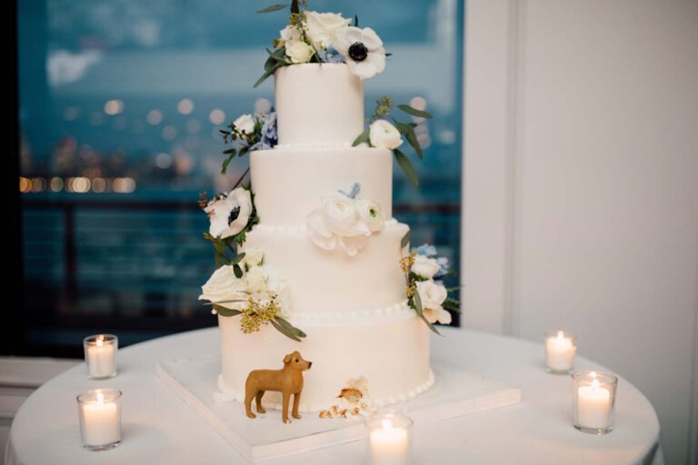 The wedding cake with candles and the water behind, from the Hudson House wedding, Cottonwood Studios