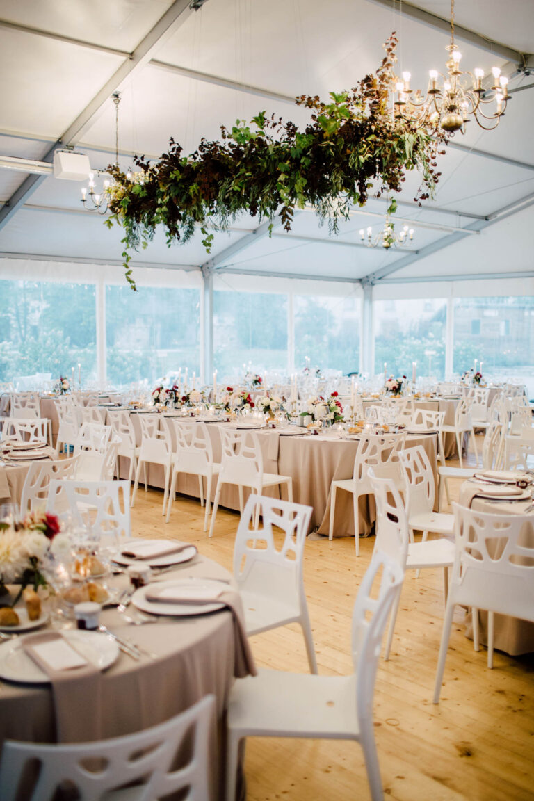 Marquee tables under a hanging floral chandelier, from a French chateau wedding, Cottonwood Studios