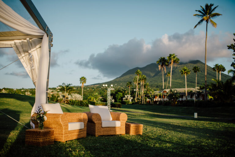 Lounge furniture on the lawn with palms and a mountain beyond, from the Caribbean destination wedding, Cottonwood Studios