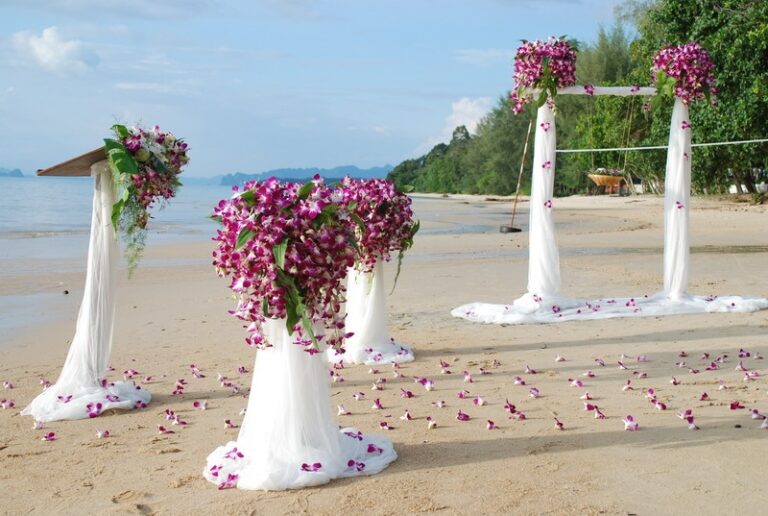 Orchid-dressed arch and aisle posts set on a Thai beach for a ceremony, Creative Events Asia