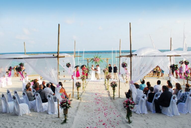 Guests seated along a white aisle on the beach under draped fabric, Creative Events Asia