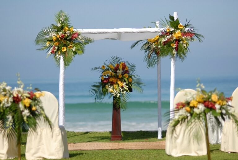 A tropical floral arch with garden chairs facing the sea, Creative Events Asia