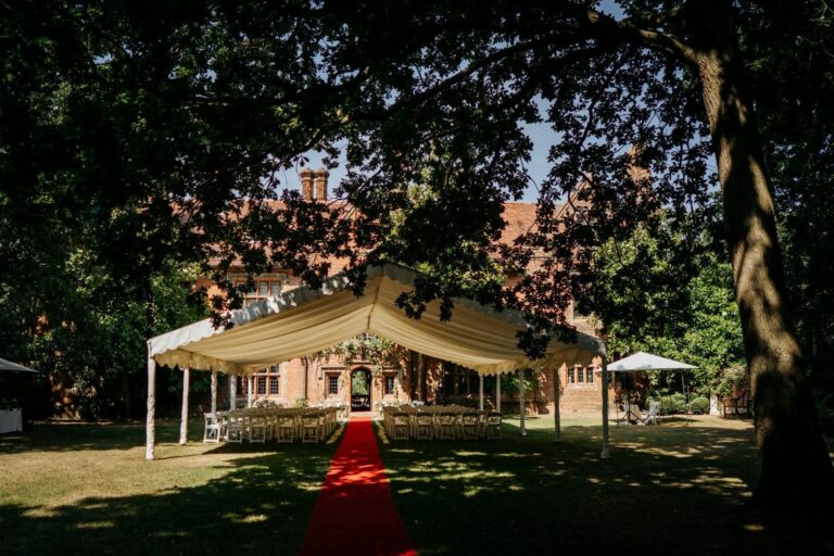 The silk canopy and red-carpet aisle set on the lawn before the house, Creeksea Place