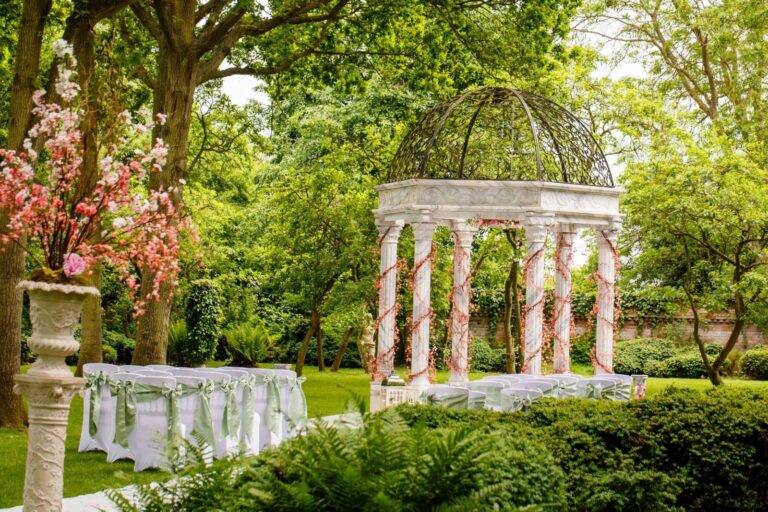 The marble gazebo with spring blossom, chairs and table set for a ceremony, Creeksea Place