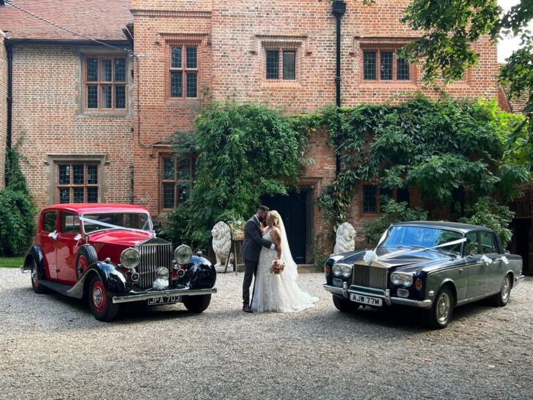The couple with two vintage wedding cars against the Tudor facade, Creeksea Place