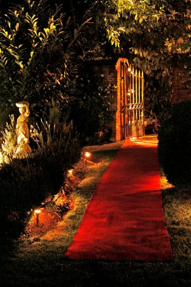 The red carpet through the lit garden gate at night, Creeksea Place
