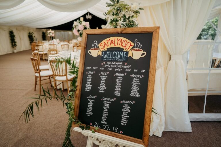 The marquee interior, chalkboard seating plan, silk lining and foliage, Creeksea Place