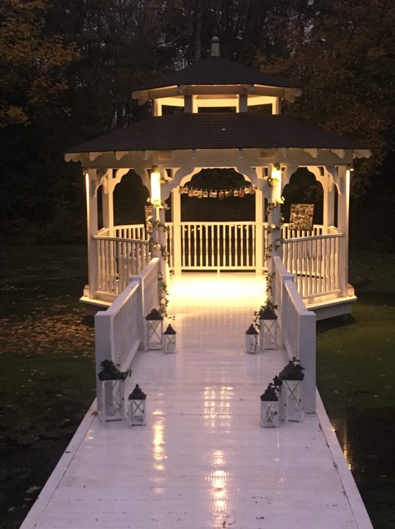 The Lake Pavilion lit at night, lanterns along the bridge, Creeksea Place