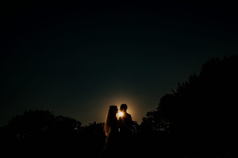 The couple silhouetted against the moon over the treeline, Creeksea Place