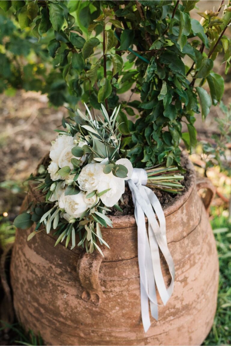 Olive leaves and white roses tied with ribbon in a clay pot, Crete for Love
