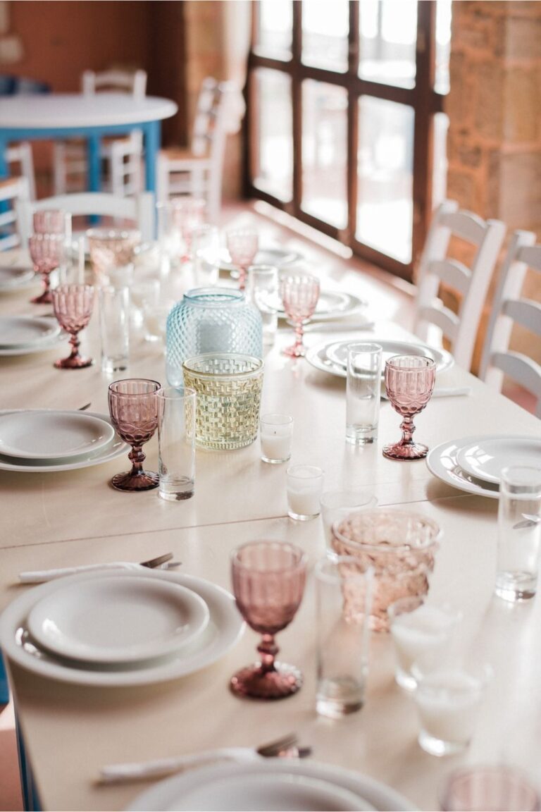 A table laid with plates and coloured glassware in a whitewashed dining room, Crete for Love