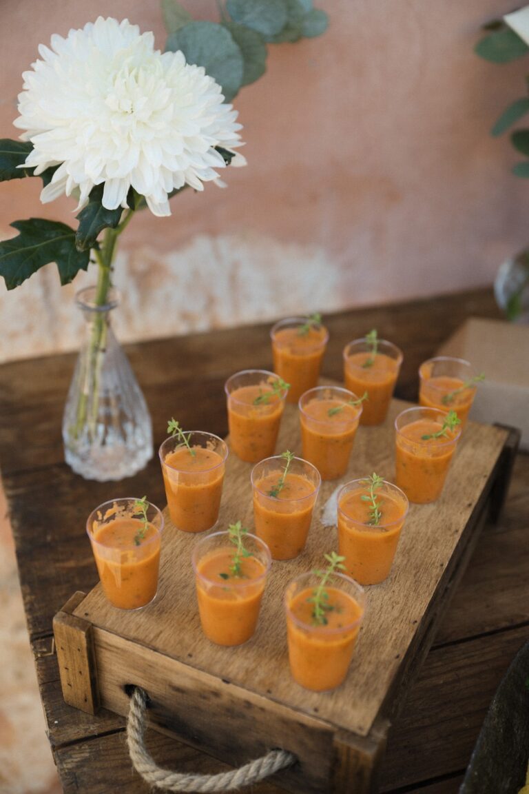 Gazpacho served in shot glasses on a wooden crate with a white dahlia, Crete for Love