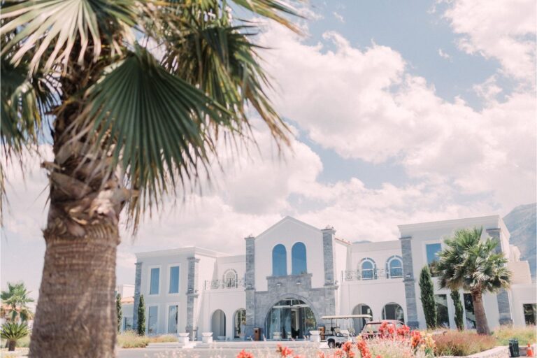 A white estate with arched windows and palm trees used for a Greek Orthodox wedding, Crete for Love