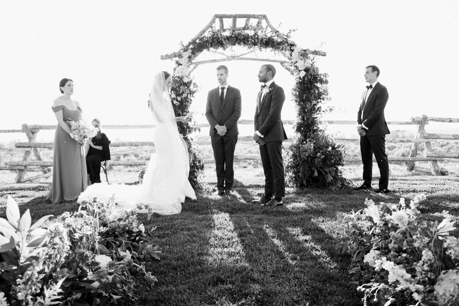 A couple exchanging vows beneath a floral arch among flower beds, Wyoming