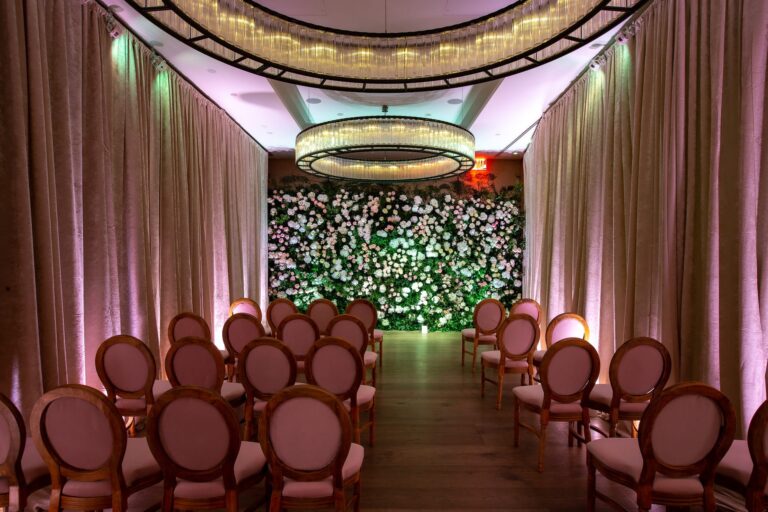 A ceremony room with a flower wall backdrop and rose-coloured chairs, New York, Cristina Verger Event Planning and Production