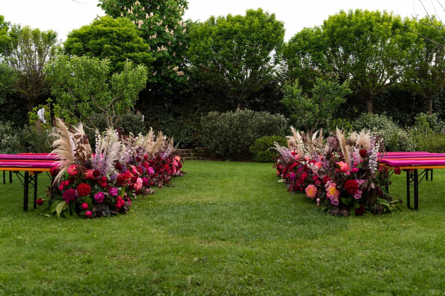 Peonies, pampas grass and garden flowers lining a lawn aisle in Tuscany