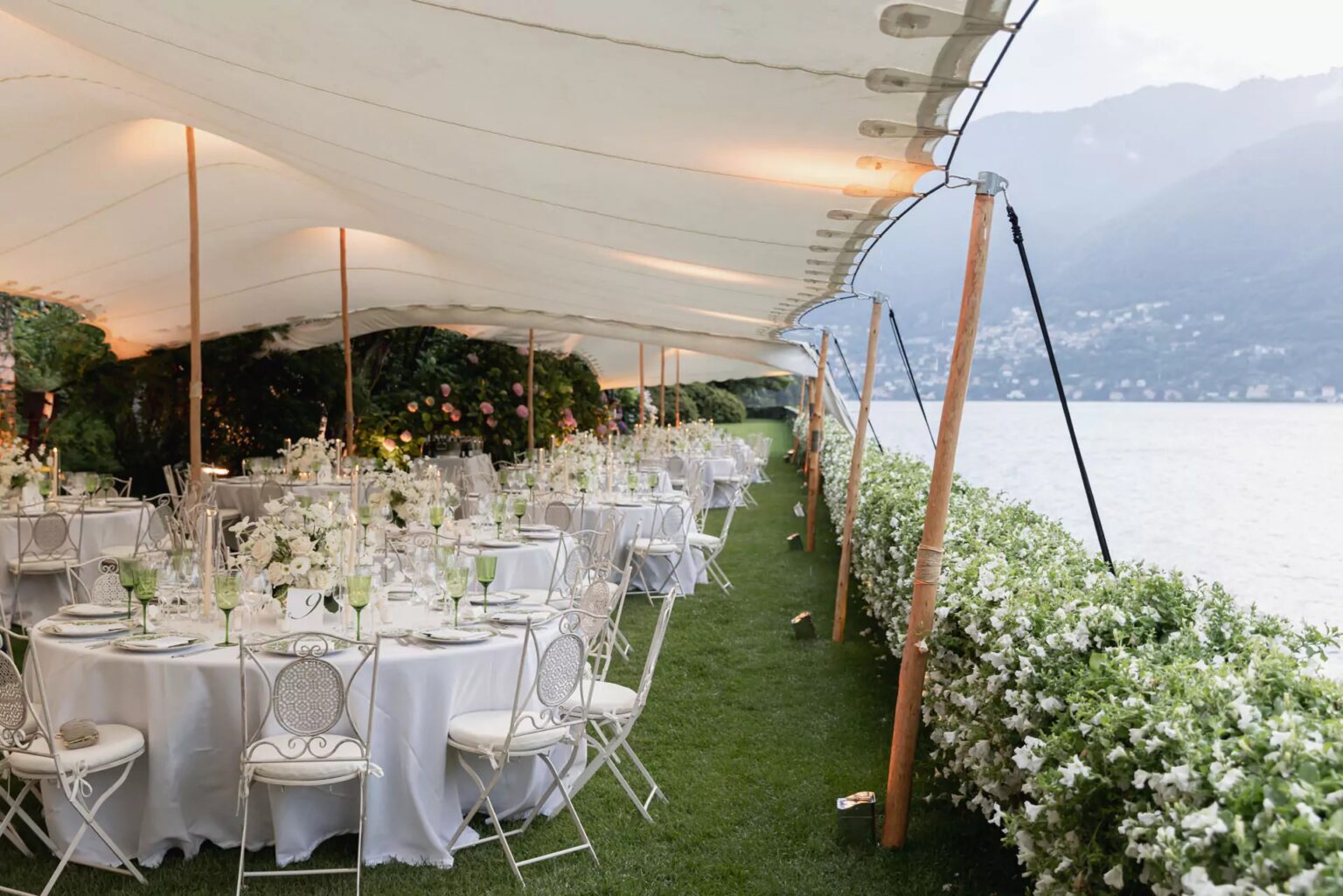 Round tables under a white tented canopy beside the lake, Lake Como