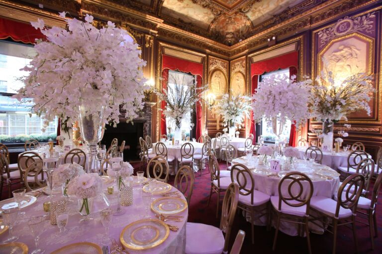A gilded ballroom with round tables and large white orchid arrangements, New York, Cristina Verger Event Planning and Production