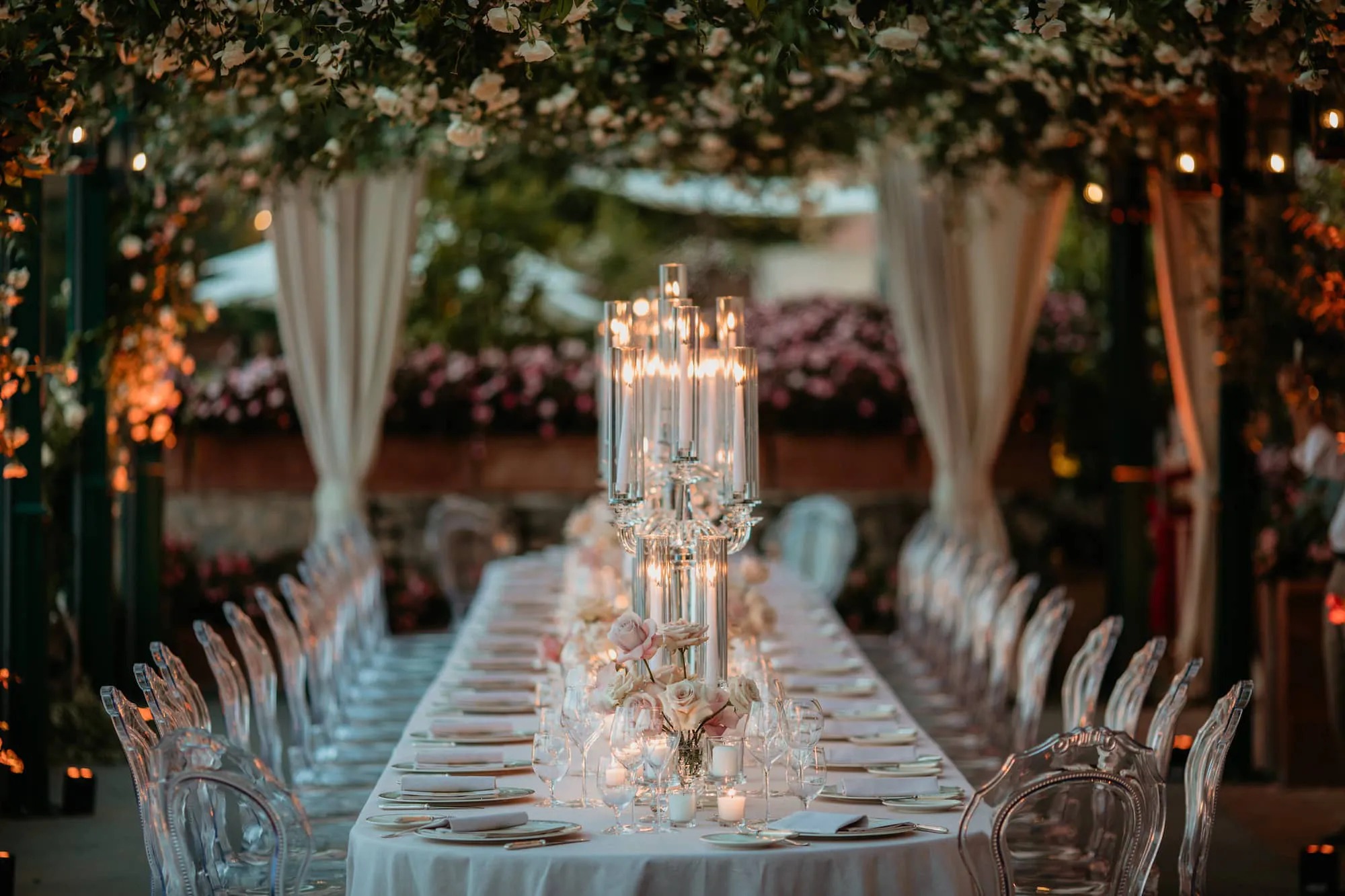 Candlelit long table with low roses and glass candlesticks under a vine canopy, Ravello, Cristina Verger Event Planning and Production