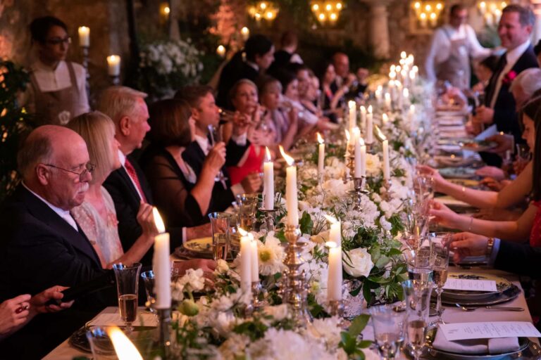 Guests at a long candlelit dinner table dressed with white flowers, Tuscany, Cristina Verger Event Planning and Production