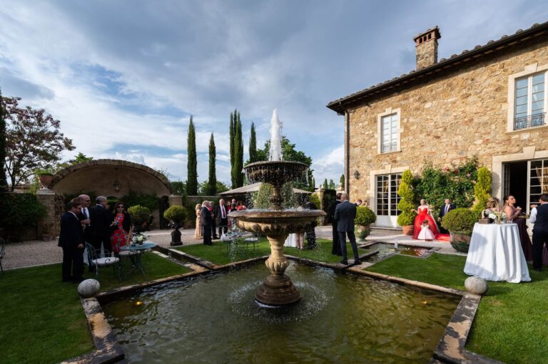 Guests gathering by a fountain in a stone villa courtyard, Tuscany, Cristina Verger Event Planning and Production