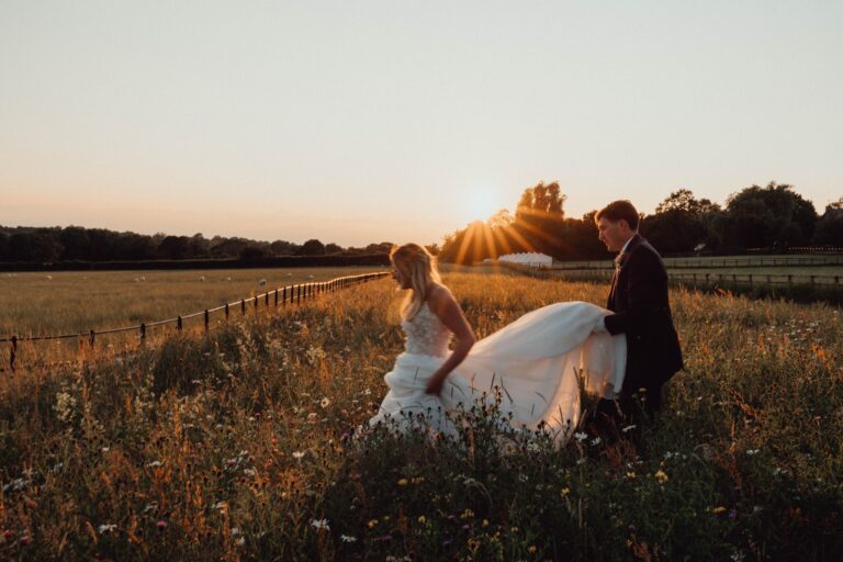 A couple walking through wildflowers at sunset on the farm, Crockwell Farm
