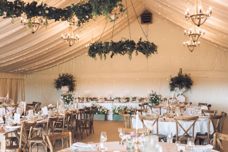 The starlit marquee with round tables in white linen and a long top table under the fairy-light canopy, Crockwell Farm