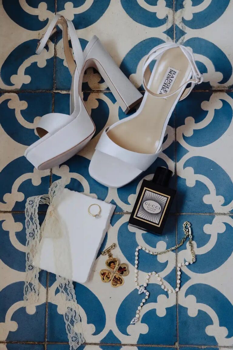 Bridal shoes, rings and perfume laid out on blue patterned tiles, Cygnus Events