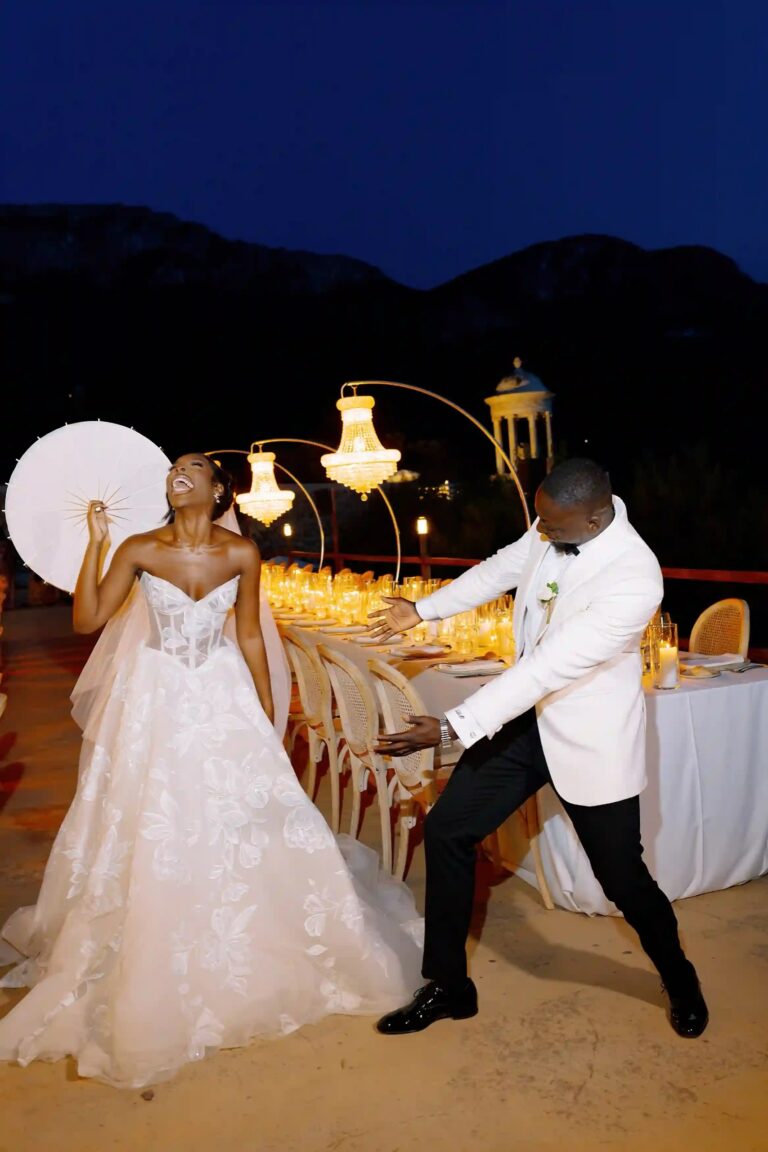 A bride and groom dancing at dusk beside a lit dinner setting and the pavilion, Cygnus Events
