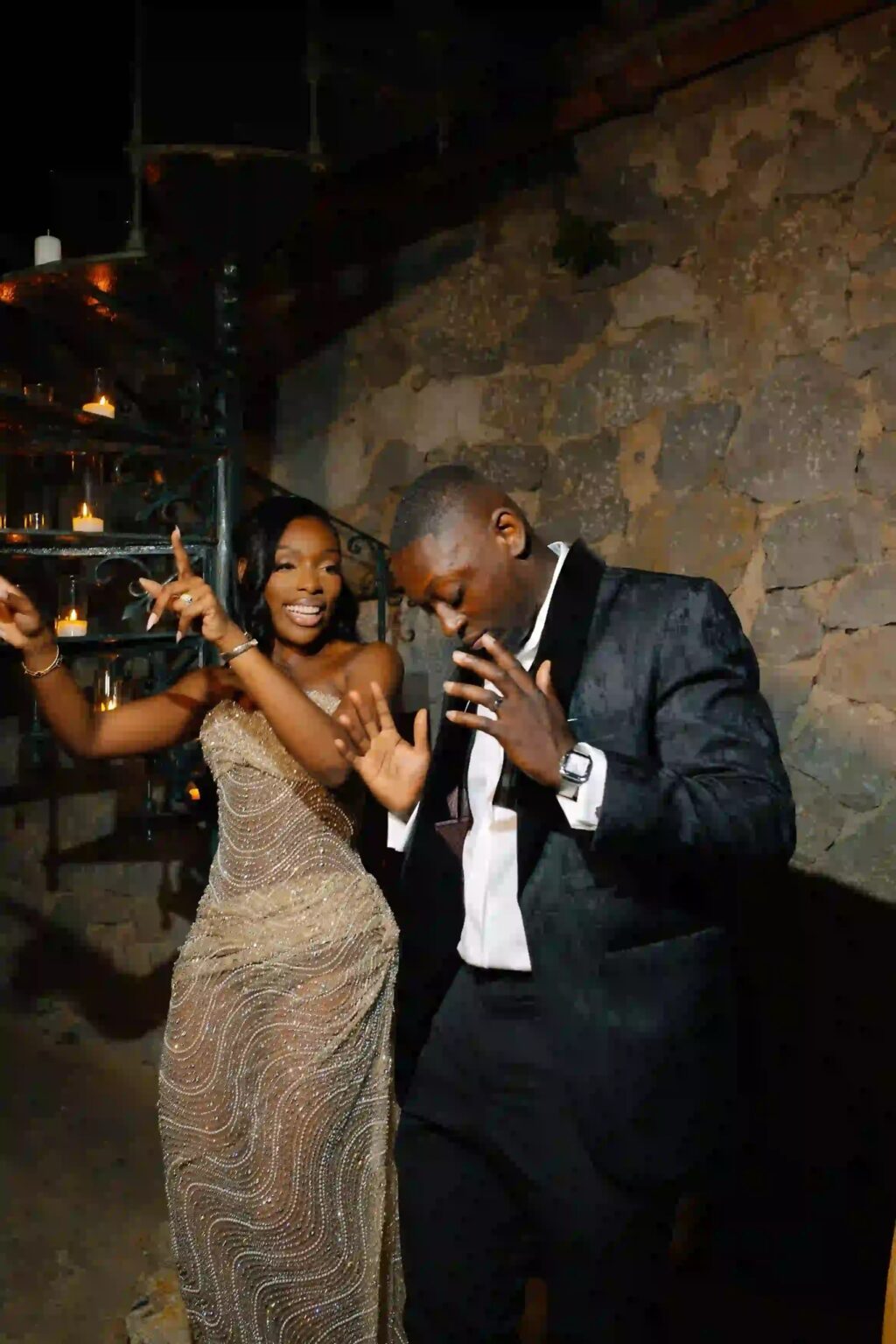 A couple dancing at the reception against a stone wall
