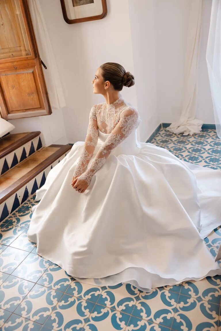 A bride in a satin gown seated on a tiled floor in a Mallorcan finca, Cygnus Events
