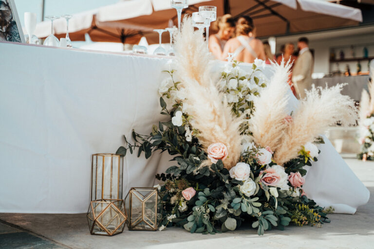 Pampas grass and rose arrangement with gold lanterns at the top table, Cyprus Wedding Touches
