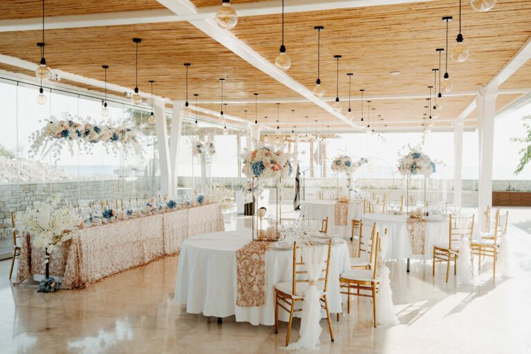 Reception hall with a timber ceiling, rose-gold top table and gold chairs, Cyprus Wedding Touches
