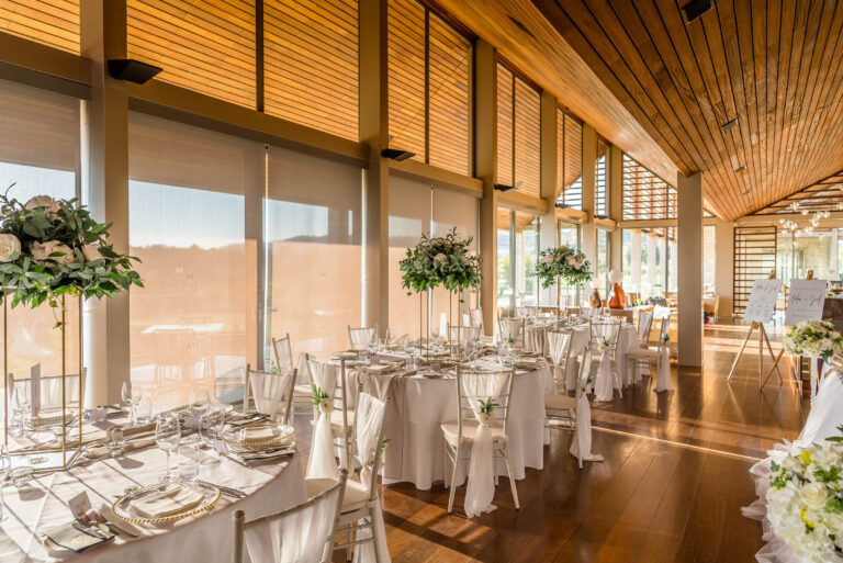 Glazed reception room with tall centrepieces and round tables, Cyprus Wedding Touches