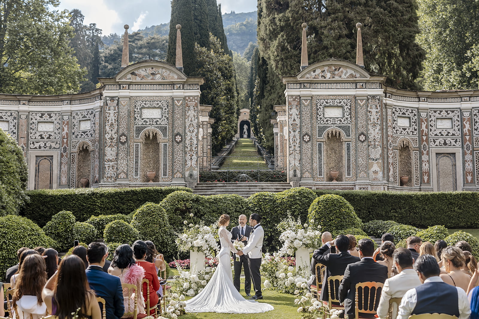 A ceremony in the gardens of Villa d'Este on Lake Como, guests seated before the mosaic nymphaeum, Daniele Vertelli Photography