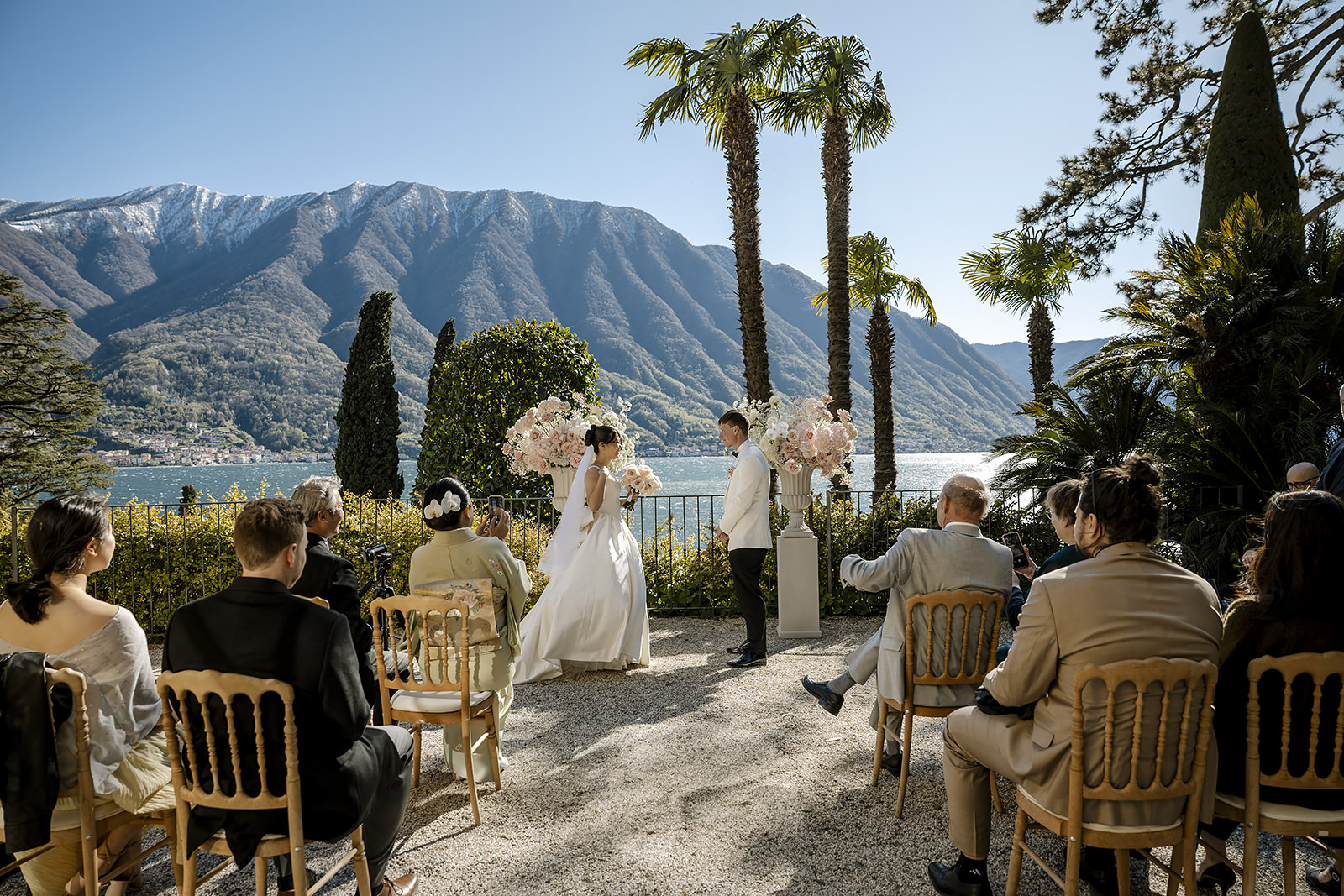 A small ceremony on a lakeside terrace on Lake Como, the mountains across the water, Daniele Vertelli Photography
