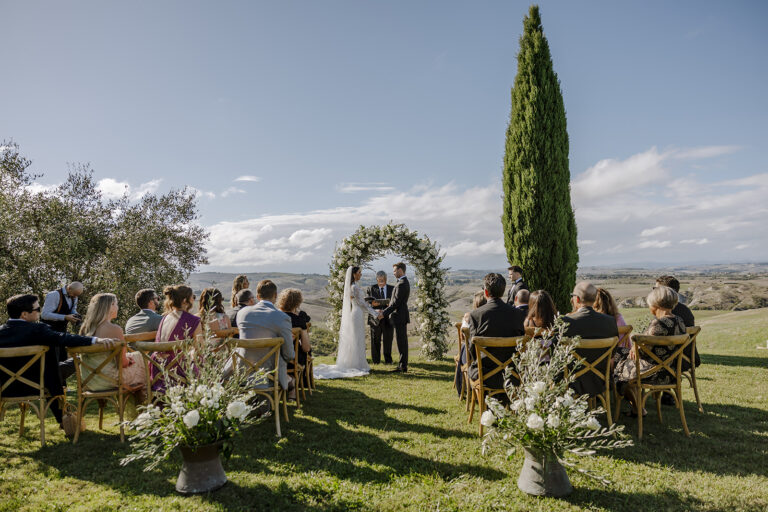 An outdoor ceremony beneath a cypress at The Lazy Olive in the Tuscan countryside, Daniele Vertelli Photography