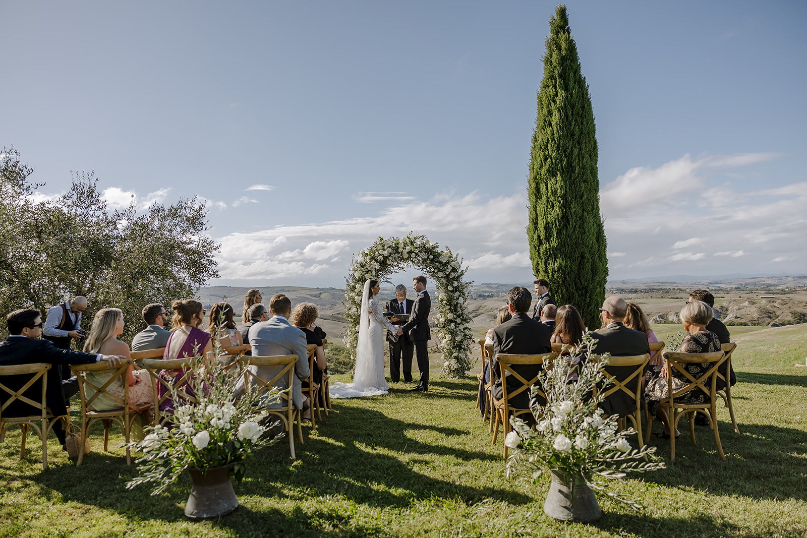 An outdoor ceremony beneath a cypress at The Lazy Olive in the Tuscan countryside, Daniele Vertelli Photography