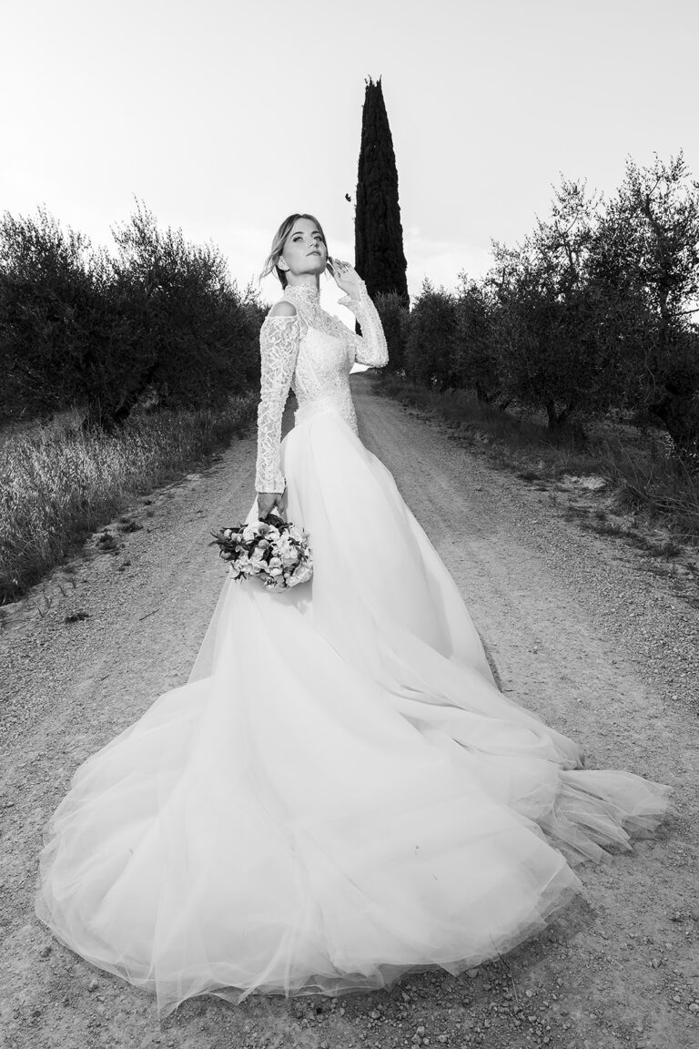 A bride on a cypress-lined road in Chianti, black and white, Daniele Vertelli Photography