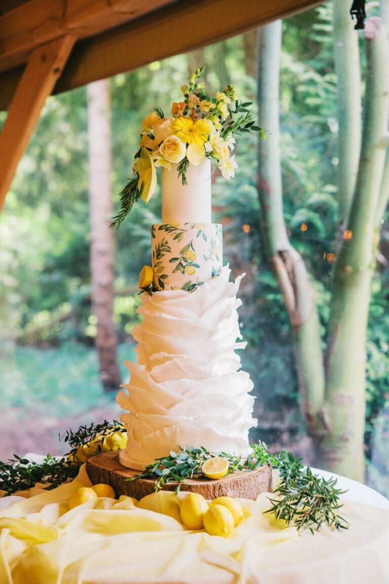 A wedding cake with yellow and orange sugar flowers, outdoors, Danielle's Cakes Pershore