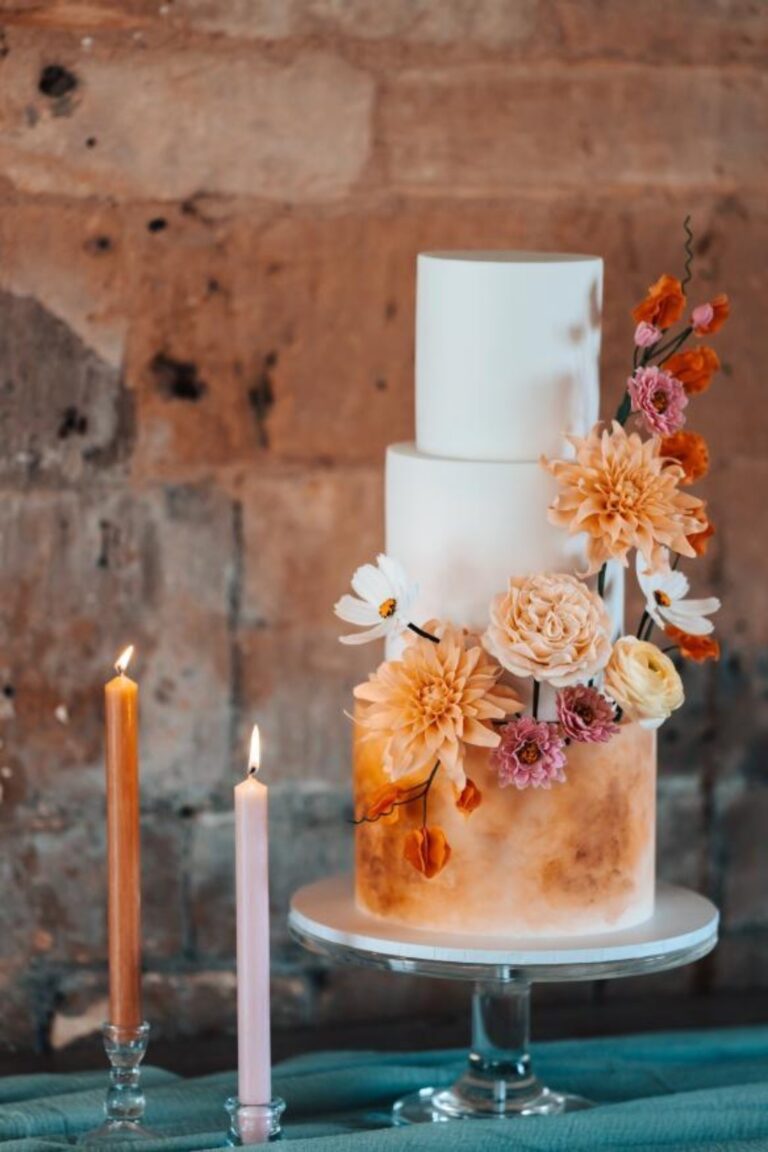 A pale blue wedding cake with orange sugar flowers and candles, Danielle's Cakes Pershore