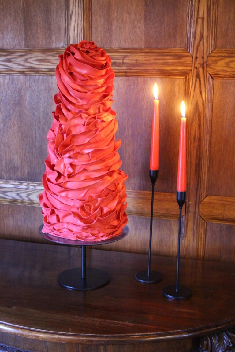 A ruffled red wedding cake beside candles, Danielle's Cakes Pershore