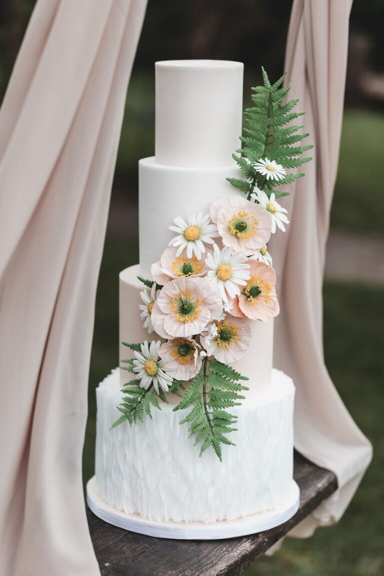 A white wedding cake with sugar flowers against a curtain, Danielle's Cakes Pershore