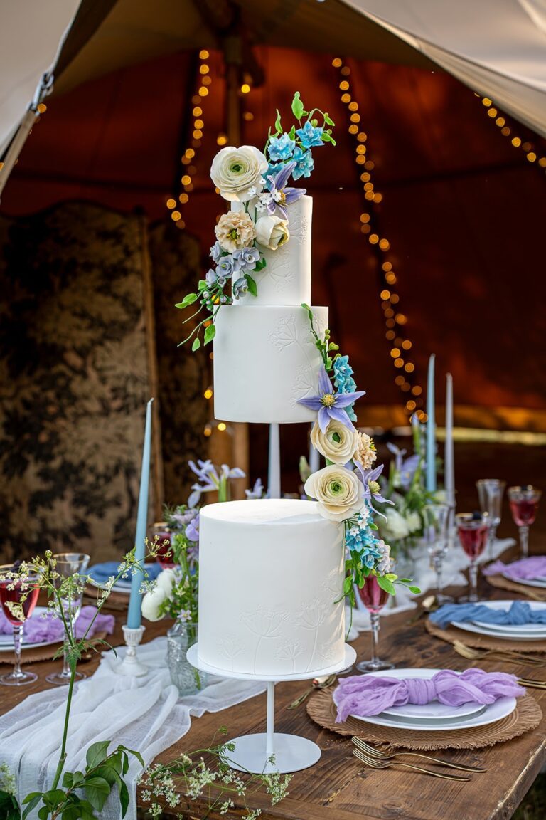 A white wedding cake with sugar flowers on a candlelit table, Danielle's Cakes Pershore