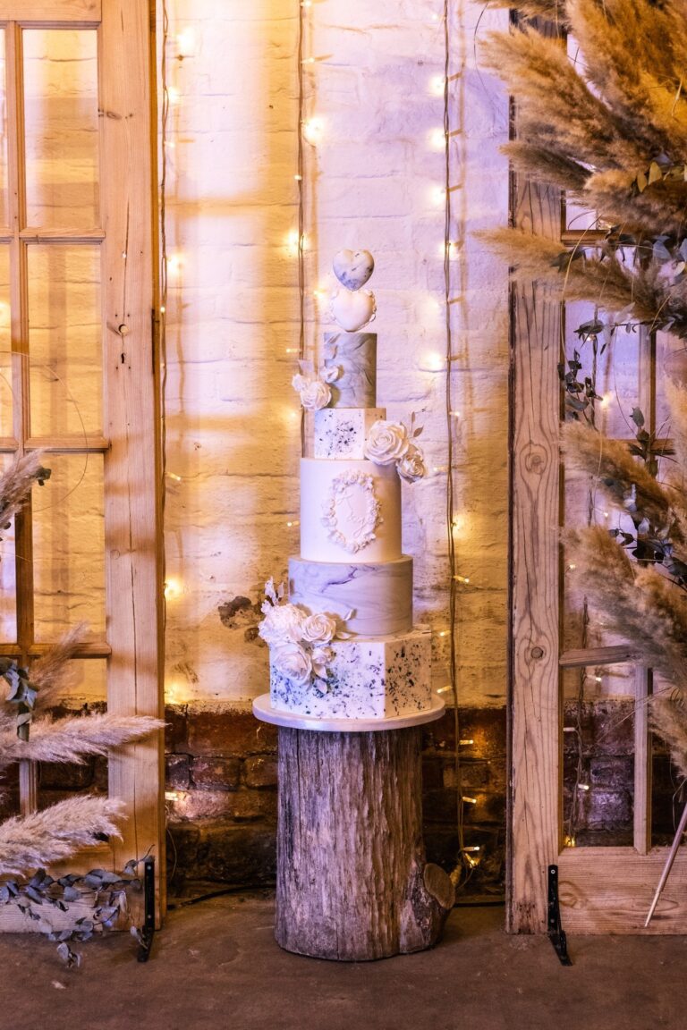 A tall sculpted wedding cake with white sugar flowers, Danielle's Cakes Pershore