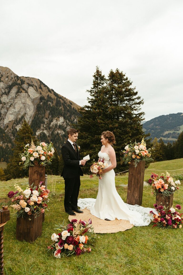 Alpine meadow ceremony ringed with flower arrangements on wooden stumps, Gstaad, Switzerland, Daria Events and Weddings